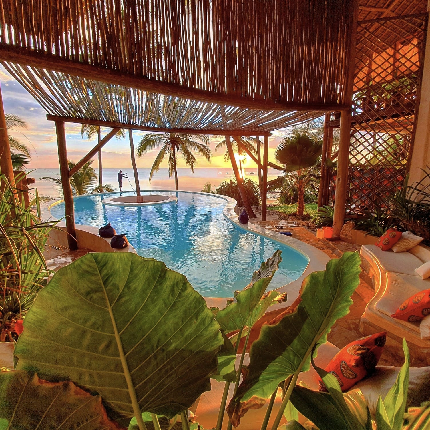Asili House pool seen from the lounge under its thatched roof in the early morning